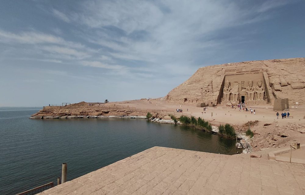The rock-cut temple of Abu Simbel above the water, its colossal seated statues in the cliff face