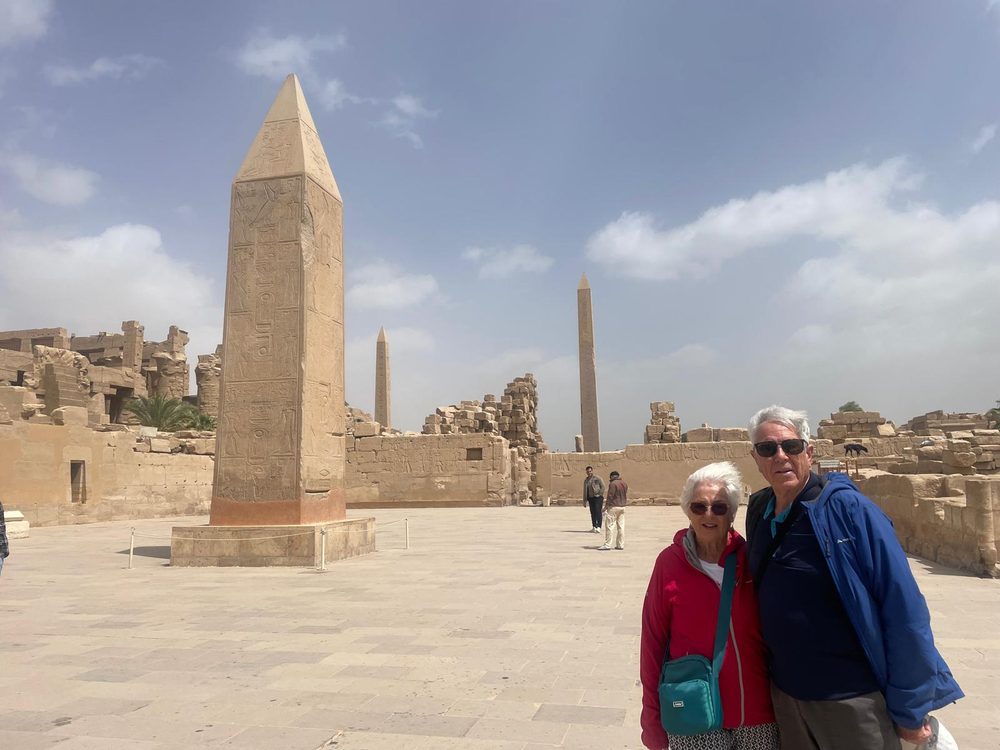 Two Explorers standing beneath the obelisks at Karnak Temple